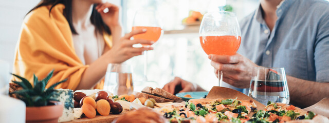 Romantic couple on a dating having dinner with lots of delicious food and glass of wine. Wide screen, panoramic