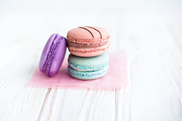 Close up view of three French macaroons on a white background. Sweet and colorful French macaroons. Dessert. Homemade sweets. Café dessert. Selective focus
