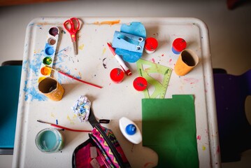 Closeup horizontal shot of a painting table with watercolor palette, other painting  materials