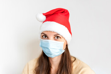 Caucasian sad woman with medical mask and Santa hat. Christmas alone on quarantine