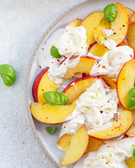 Fresh salad with peaches, Italian Stracciatella cheese, Basil, olive oil and honey. Summer salad, healthy food concept. Selective focus