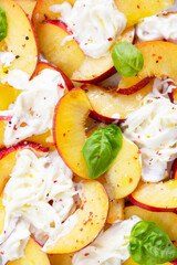 Fresh salad with peaches, Italian Stracciatella cheese, Basil, olive oil and honey. Summer salad, healthy food concept. Selective focus