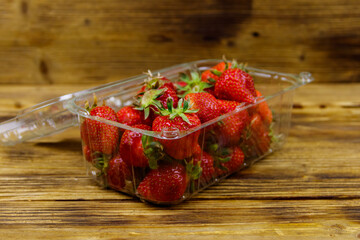 Fresh strawberry in plastic box on a wooden table