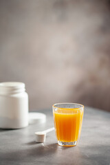 Powder collagen puts hand in glass of citrus juice.