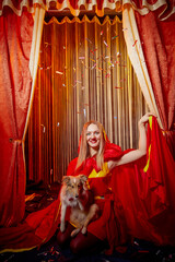Beautitul girl during stylized theatrical circus photo shoot in beautiful red location. Female...