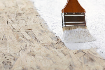 Brush painting wall with white paint close up