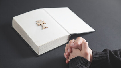 girl hands praying on the bible.