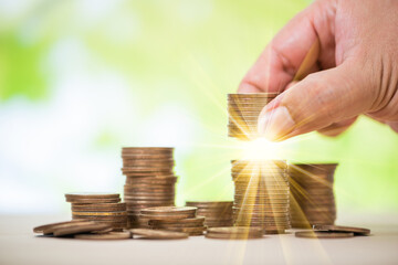 man hand top up stack of coins , business and saving concept