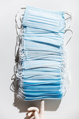 Woman hands in latex gloves holding a stack of facial medical masks, white background, close up