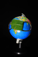 Rejuvenation of earth during Covid19 situation. Concept of Coronavirus in world and COVID-19 pandemic. Globe protected by green leaf. Conceptual photography. Earth globe isolated on a black background