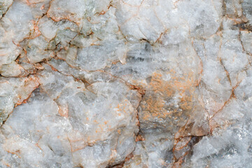 Light rough surface of marble with red stains. Closeup of raw uneven stone, natural material, beautiful rock texture. Abstract background.