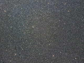 Grey textured background with multicolored sequins. Space for text.