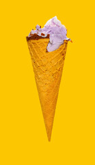 side view sweet potato flavor ice cream cone with couple of bites on yellow background