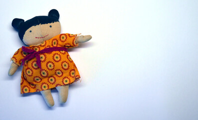 Handmade doll in a yellow dress on a white background
