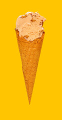 side view milk tea flavor ice cream cone with couple of bites on a yellow background