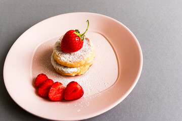 Delicious cheesecakes pancakes, decorated with fresh strawberries. Horizontal orientation.