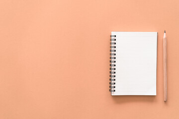 Notebook and pencil on pastel color texture background.