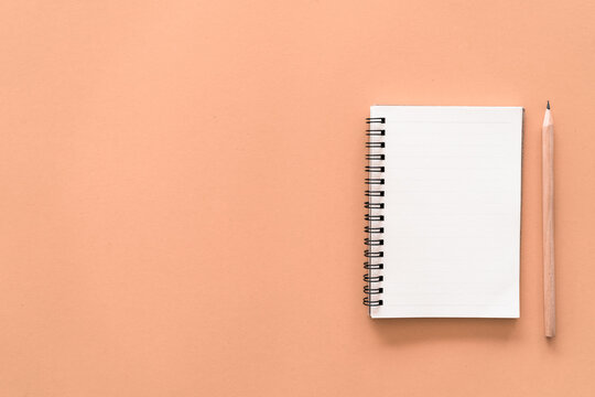 Notebook and pencil on pastel color texture background.