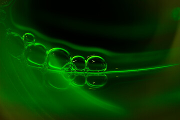 Soap bubbles on a rich green neon background.The shape and texture of the foam.gradient green...