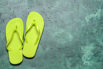 Stylish flip-flops on color background