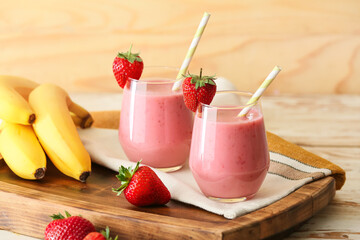 Glasses of tasty strawberry smoothie on table