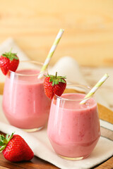Glasses of tasty strawberry smoothie on table