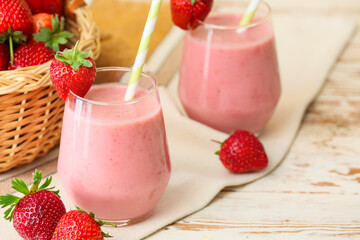 Glasses of tasty strawberry smoothie on table