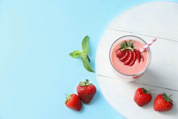 Glass of tasty strawberry smoothie on color background