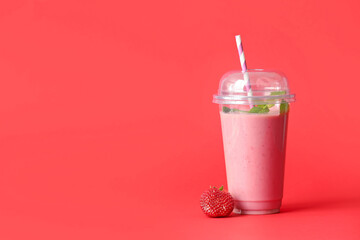 Cup of tasty strawberry smoothie on color background
