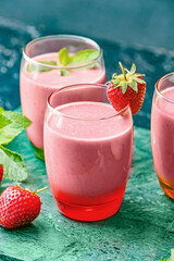 Glasses of tasty strawberry smoothie on table