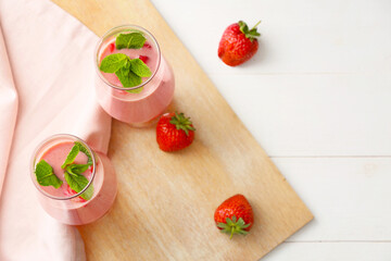 Glasses of tasty strawberry smoothie on table