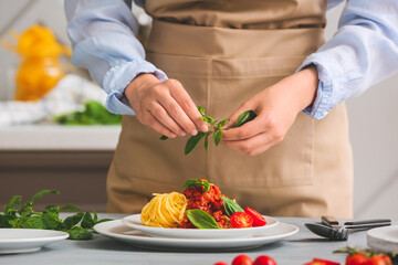 Woman cooking tasty pasta bolognese in kitchen, closeup