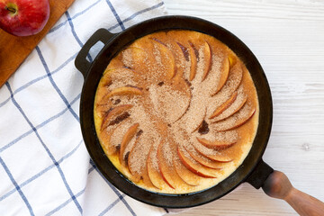 Cooking Apple Dutch Pannekoek Pancake on a white wooden background, top view. Overhead, from above, flat lay.