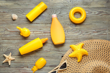 Sunscreen cream with beach sand toys and accessories on wooden background