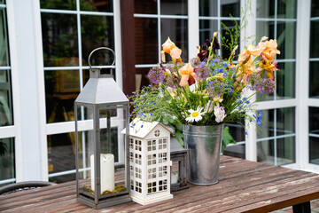 table in garden of country house. candlesticks and bouquet of flowers.