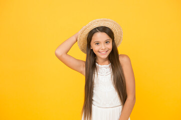 Enjoying summer. long-awaited summer vacation. happy childhood. cheerful little girl wear straw hat. beach fashion for kids. small child on yellow background. holiday joy and activity. beauty