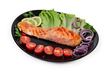 Grilled trout fillet among vegetables and greens on black dish