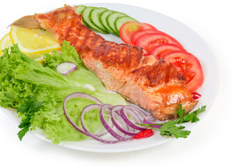 Portion of grilled trout fillet among the vegetables and greens