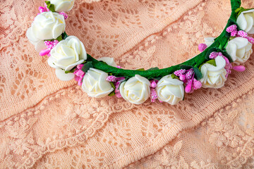 Headband or wreath of hand made white and pink flowers. Wedding background. Vintage accessory on delicate ivory-colored lace cloth.