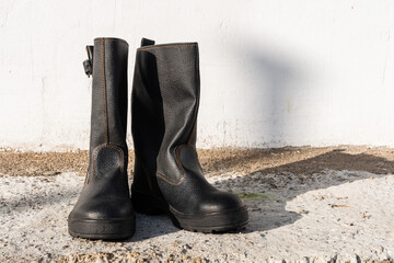 A pair of black high boots outdoors.