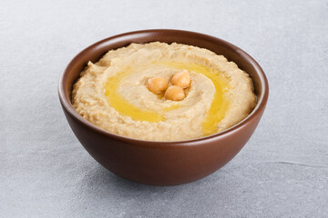 Chickpeas hummus with olive oil on a gray background.