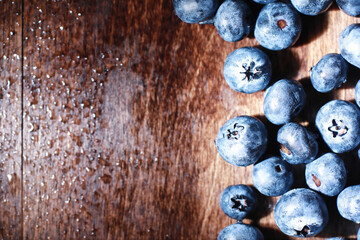 Water drops on ripe sweet blueberry. Fresh blueberries background with copy space for your text. Vegan and vegetarian concept. Macro texture of blueberry berries.