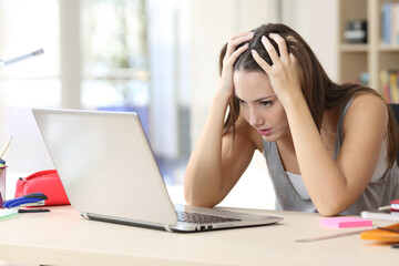 Stressed student memorizing on laptop studying at home