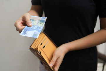 woman pay 50000 rupiah open wallet