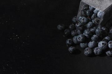 Water drops on ripe sweet blueberry. Fresh blueberries background with copy space for your text. Vegan and vegetarian concept. Macro texture of blueberry berries.