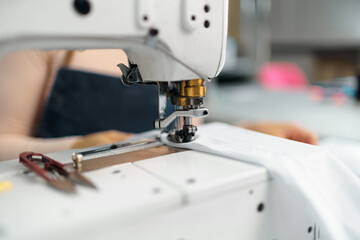 Close up of a seamstress with a sewing machine