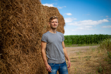 A young guy near a stack of wheat. Harvesting of wheat, Shavuot