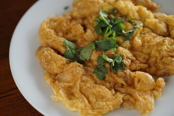 Top view of Omelet top with coriander on wood table.(Thai style)