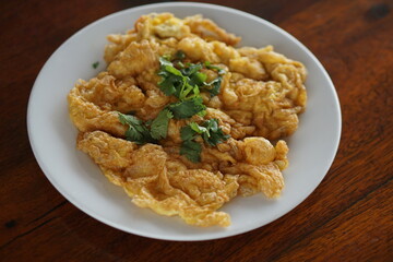 Close up top view of Omelet and top with coriander on wood table.(Thai style)