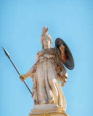 Athena marble statue with helmet, spear and shield under clear blue sky, Athens Greece